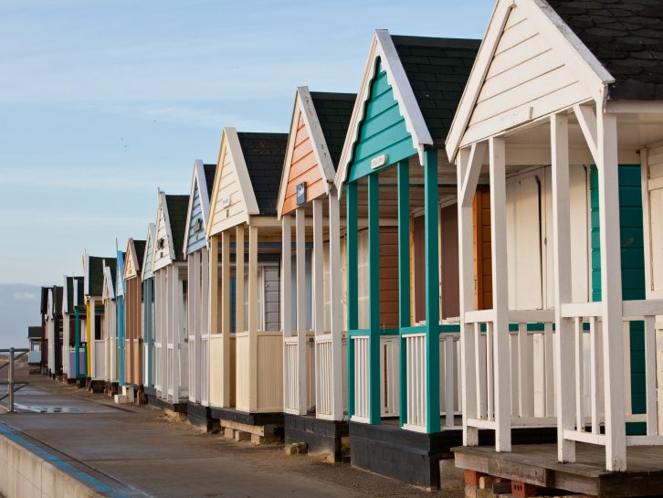 Colourful beach huts line the long sandy beach at Southwold on the Suffolk coast