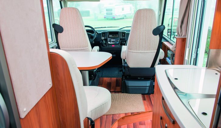 The white upholstery and trim sitting alongside the mid-toned wood gives the Hymer Exsis-i 578's interior an elegant and refined feel