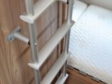 A ladder attached to the washroom wall gives access to the caravan's top bunk