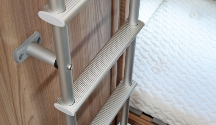 A ladder attached to the washroom wall gives access to the caravan's top bunk