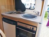 The well lit kitchen in the Bailey Approach Advance 615 motorhome has a tiny worktop, but there's a combined oven and grill, an 80-litre fridge-freezer, three-burner hob, and sink