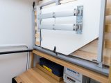 The dinette table extension cleverly stows under the rear bed. The cupboard underneath is home to the electrical consumer unit