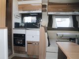 The L-shaped, Continental kitchen is cosy but practical – note that the hinged table is folded in the right of this image