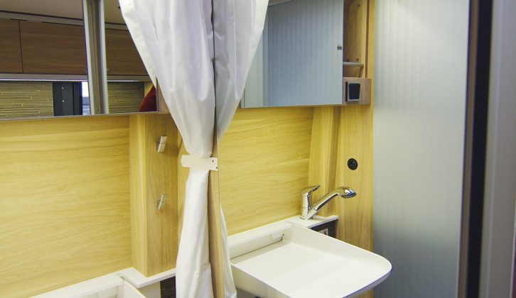 It’s unusual to see a proper bathroom cabinet and a large mirror in such a compact washroom. A shower curtain keeps things tidy in the Sierra Nevada van conversion's washroom