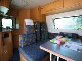 Features of this 2000 Adria Van include an L-shaped kitchen and a bathroom