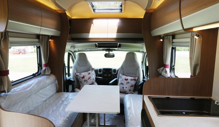 A freestanding table fits between the parallel lounge seats at mealtimes – read more in the Practical Motorhome Auto-Trail Imala 715 review