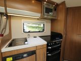 The kitchen in this Auto-Trail motorhome has a separate oven and grill, a four-burner dual-fuel hob, and a microwave fitted at shoulder height