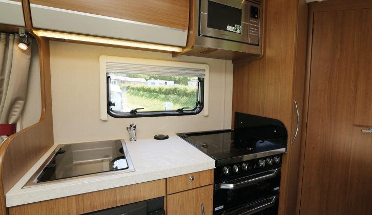 The kitchen in this Auto-Trail motorhome has a separate oven and grill, a four-burner dual-fuel hob, and a microwave fitted at shoulder height
