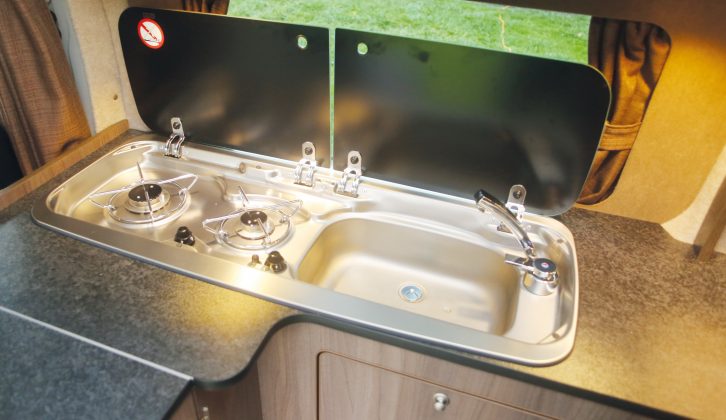 A two-burner gas hob and sink comprise a single stainless-steel unit, and separate glass lids increase space for preparing meals