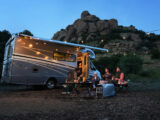 Friends sitting outside a motorhome, using an EcoFlow power pack
