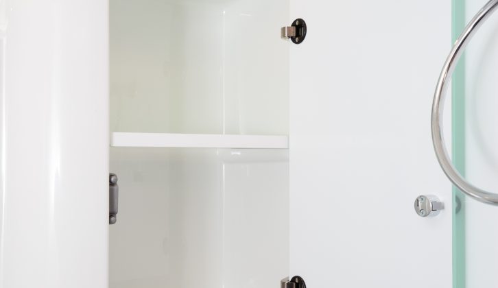 A cupboard for lotions and potions plus a half-length mirror complete the fittings in the washroom