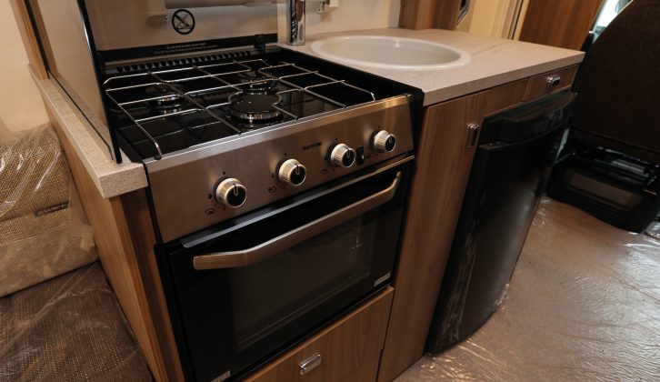The three-burner hob has a handy splashguard to its left and a combined oven and grill below it