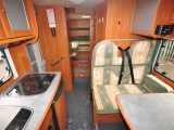 The side dinette in the Dethleffs offers two further belted seats. The kitchen is small with covered sink and hob serving as worktop