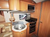The well-designed kitchen has rafts of storage and worktop, a separate oven and grill, dual-fuel hob and microwave