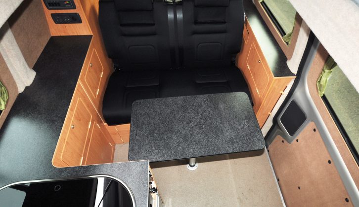 The tabletop is supported by a pedestal leg. Only the passenger’s seat swivels, due to the L-shaped kitchen cabinet