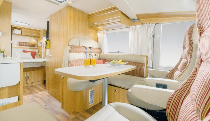 The lounge in a Hymer Exsis-i 698 features Trentino Pear cabinetwork