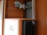 The TV mounting bracket is behind a tambour door, above the 160-litre fridge which is opposite the main kitchen area