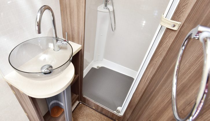 The washroom features a fully lined separate shower cubicle and a large salad-bowl style basin with chrome fittings