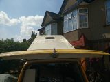 The VW camper van's roof was raised and lowered several times as work progressed. This was in the middle of the job as neither rooflight is installed