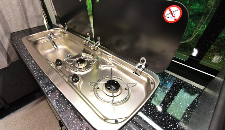 You’ll find twin gas burners mounted within a stainless-steel unit that also encompasses the sink, with glass lids covering them
