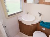 The spacious, practical washroom has a curtain to separate the shower from the rest of the room, a clear window to let lots of light in and a smart, curved washbasin