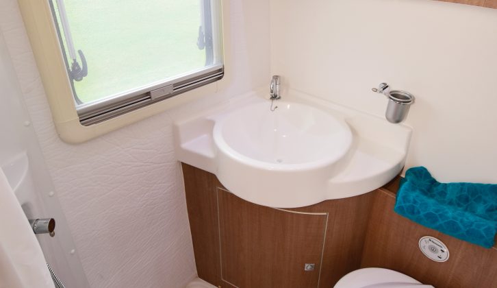 The spacious, practical washroom has a curtain to separate the shower from the rest of the room, a clear window to let lots of light in and a smart, curved washbasin