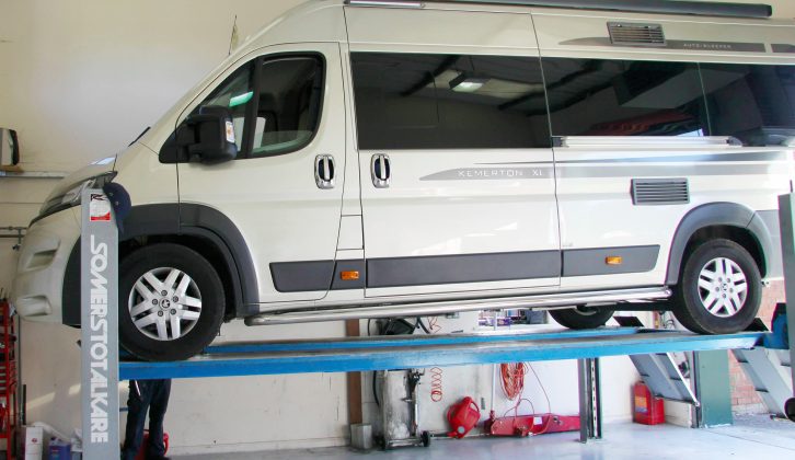 The motorhome is raised to permit the technicians to inspect the underside