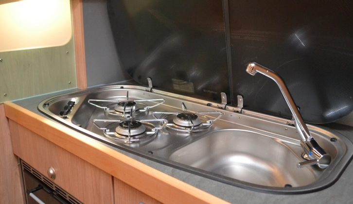 There's a splashguard to the left of the kitchen, and the camper-style sink is integrated into the hob
