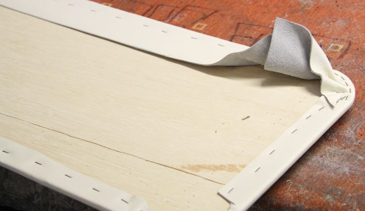 A staple gun is used to attach the leather hide to the trim panels and pelmets