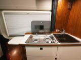 The compact side kitchen follows the familiar camper van layout, and has a work surface extension at the end of the unit