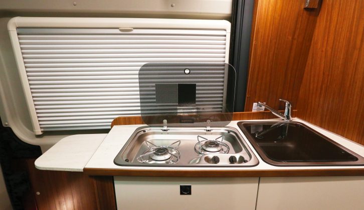 The compact side kitchen follows the familiar camper van layout, and has a work surface extension at the end of the unit