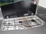 The three-burner hob’s splashback covers the window as well as the partition wall, to protect both from cooking mishaps