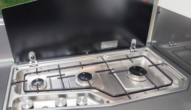 The three-burner hob’s splashback covers the window as well as the partition wall, to protect both from cooking mishaps