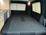 A spotlight provides focused light for night-time reading above the 1.83 x 1.17m (6'0" x 3'10") rock’n’roll bed in this four-berth ’van