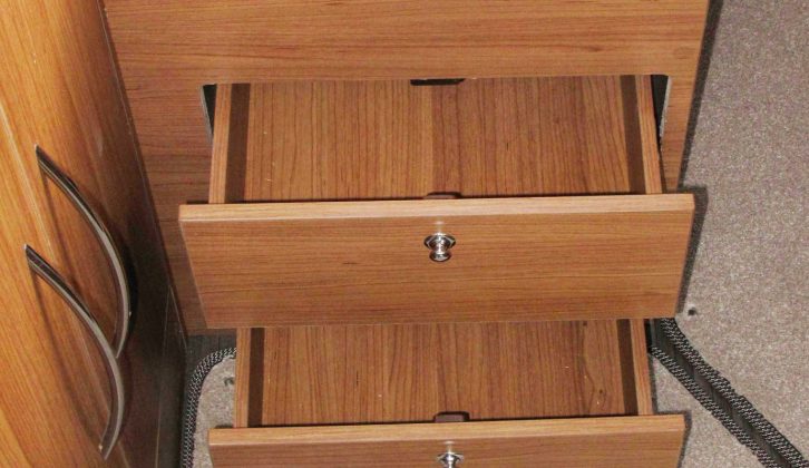 There are two small drawers next to the wardrobe and cupboard, along with a bedside table, two overhead lockers and the dresser