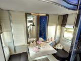The rear lounge feels large thanks to the wardrobe's mirrored doors, and has a pair of facing seats, with a fold-up table in the middle – note the retracted bunks above