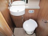 The nearside washroom features a rooflight, two cupboards, a towel ring, a swivel toilet and a lit mirror above the handbasin