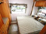 Here you can see a typical RV bedroom, with a slide-out and a peninsula bed