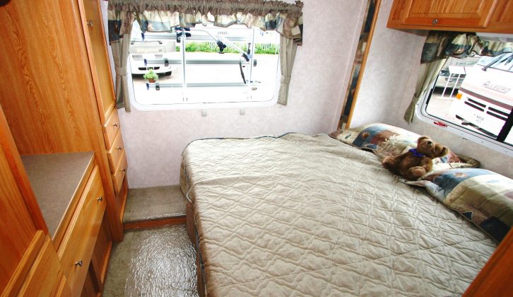 Here you can see a typical RV bedroom, with a slide-out and a peninsula bed