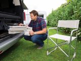 An outdoor camping table and two chairs live within a fabric bag, which is stored under the bed in the back of the Mercedes-Benz Marco Polo