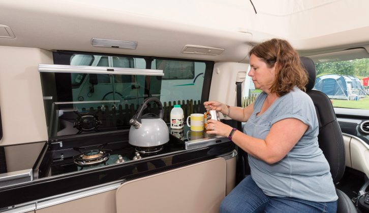 The camper van's side kitchen has a two-burner hob with a heavy glass lid