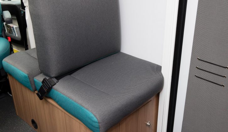 The fifth travel seat faces backwards and has no window, but it does have both a head- and footrest