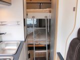 The spacious upper bunk is accessed via a ladder, which sits beside the washroom’s tambour door