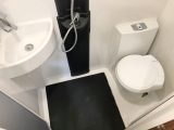 The shower cubicle isn't separate, but the black-plastic floor helps channel water into the three plugholes