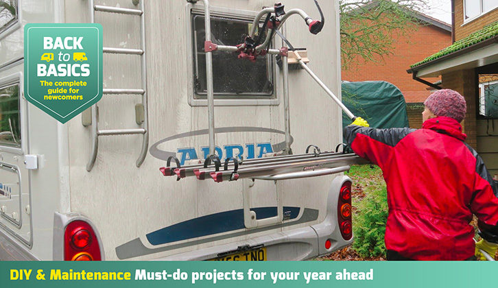 A motorhome being cleaned with a long-handled brush