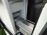 The compressor fridge with freezer compartment sites just inside the sliding door, so you can access it from inside and outside the 'van