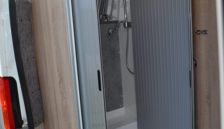 The shower cubicle is closed off with a neat tambour door