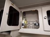 One of the kitchen cupboards contains storage for two wine bottles and a set of crystal glasses, and there's storage for four more wine bottles beneath the travel seat