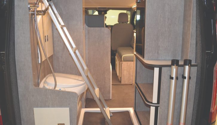 To save space, the ladder for the roof bed lies sideways across the motorhome, and stores in the rear door when not in use. The table legs are stored here, too