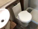Washroom features a good-sized basin and swivel-bowl cassette toilet. The shower cubicle has two plug holes